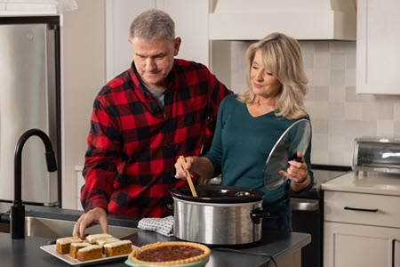 Pete and Megan from PowerHouse cooking in a kitchen